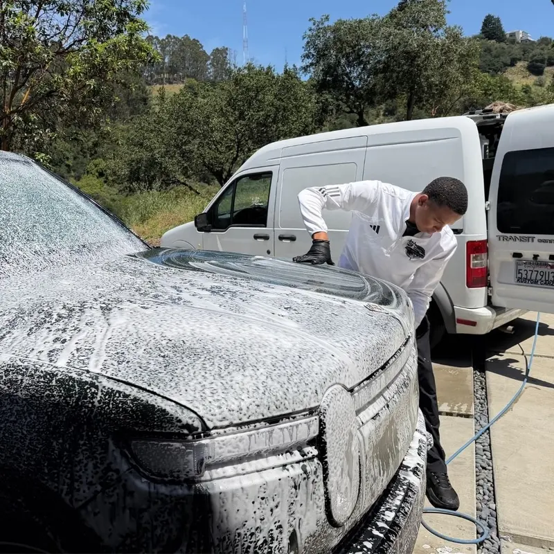 Foam pre-soak on a white sedan during a mobile exterior detail in Oakland
