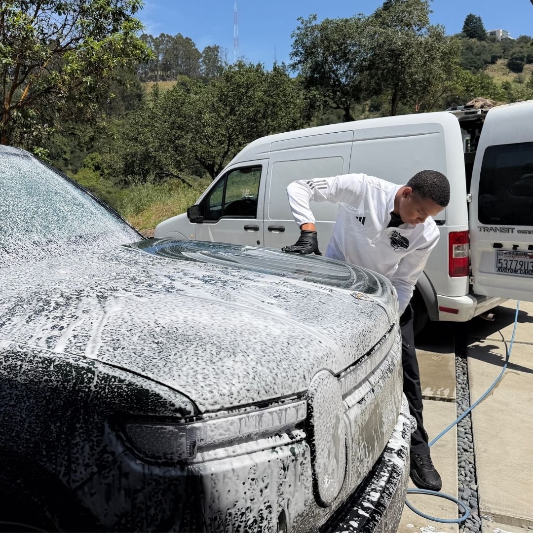 Foam pre-soak on a white sedan during a mobile exterior detail in Oakland