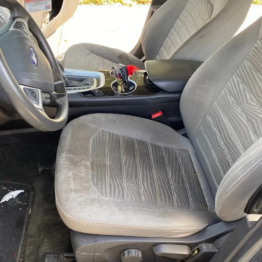 Before: heavily stained cloth seat in a sedan prior to interior detailing in Oakland