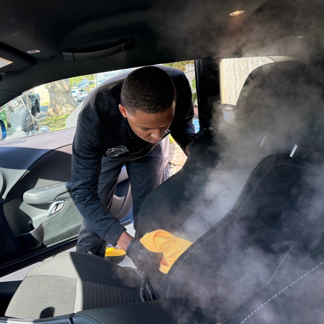 Jalil steam cleaning a car interior during a mobile interior detail in Oakland, CA