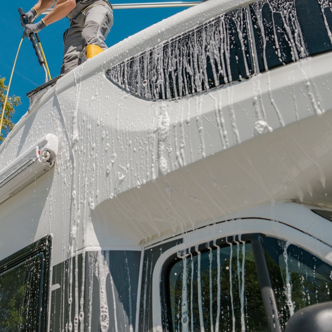 Technician washing the roof line of a motorhome during mobile RV detailing in Oakland